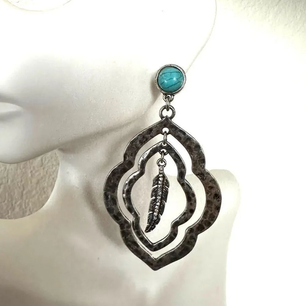 Silver tone blue feather statement earrings